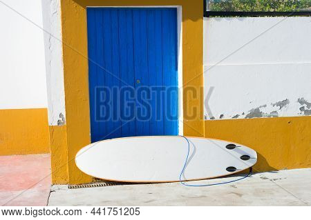 Surfboard Leaning Against Old Building Wall Ttt