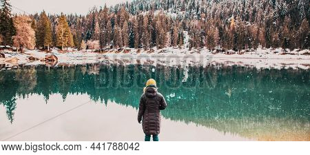 woman watchin amazing turquoise water of Caumasee in winter Switzerland slow travel