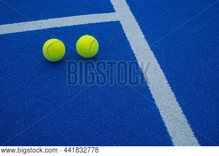 Two Paddle Tennis Balls Next To The Lines Of A Paddle Tennis Court