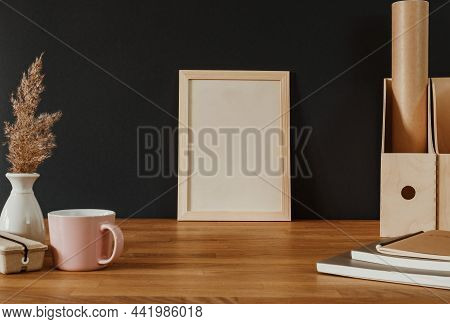 Empty White Vertical Frame On Wooden Desk