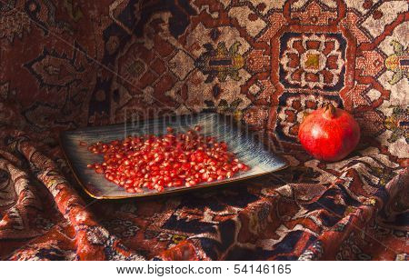 Still life of Armenian pomegranate and carpet