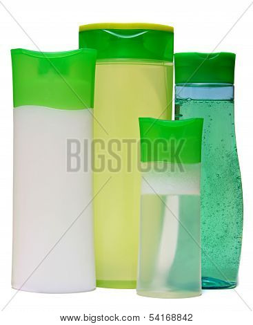 Four green plastic bottles with liquid soap, shower gel or shampoo.