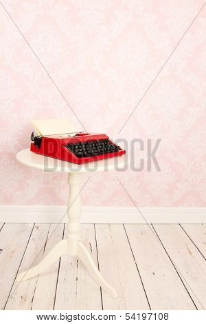 Vintage wall, wooden floor and plinth and old typewriter on table