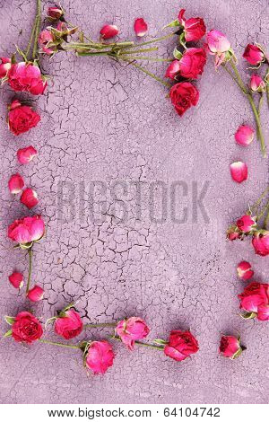 Beautiful pink dried roses on old wooden background