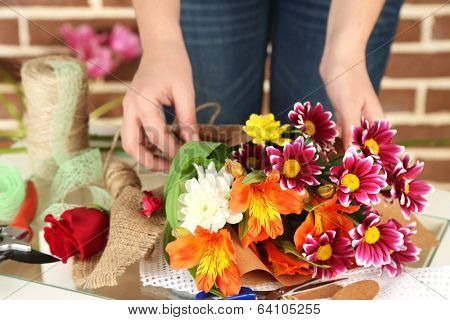 Female hands composing beautiful bouquet, close-up. Florist at work. Conceptual photo