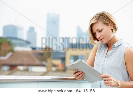 Woman On Roof Terrace Using Digital Tablet
