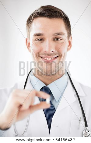 healthcare and medical concept - young male doctor offering pill