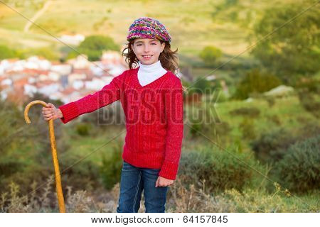 Kid girl shepherdess smiling with wooden baston in Spain village