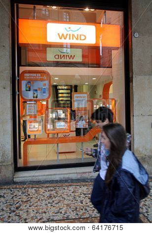 BOLOGNA, ITALY - APRIL 19, 2014: Pedestrians walk past a Wind Telecomunicazioni SpA mobile telephone store in Bologna, Italy, on Saturday, April 19, 2014. 