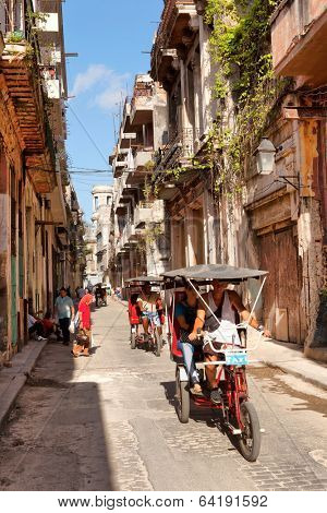 HAVANA - MAY 15: The urban cityscape, pedicab on the road on May 15, 2013 in Havana, Cuba