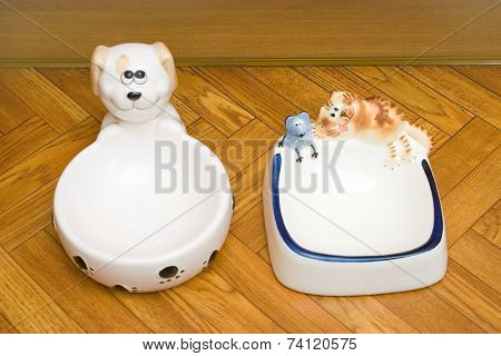 Bowls for dog and cat on parquet