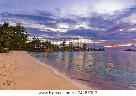Cafe on Seychelles tropical beach at sunset - nature background