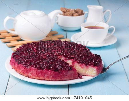 Cranberry Pudding On Blue Wooden Table With Cup Of Tea