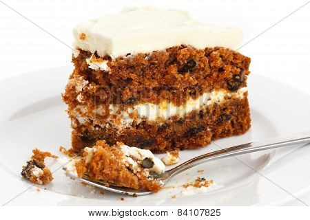 Slice of carrot cake with rich frosting. On plate