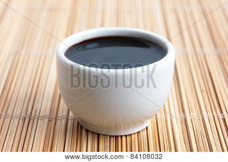 Soja sauce in small white dish.
