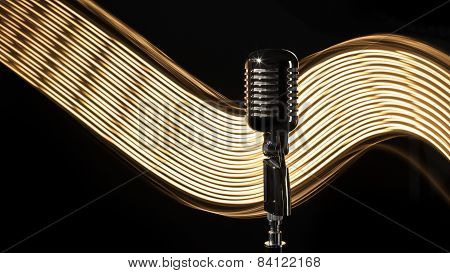 Vintage retro microphone on the black background with light wave