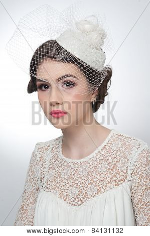 Hairstyle and make up - beautiful young girl art portrait. Cute brunette with white cap and veil