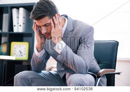 Thoughtful businessman sitting on office chair in office