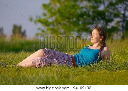 Young woman relaxing on a green meadow
