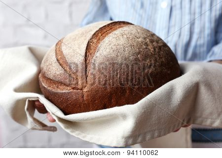 Woman holding tasty fresh bread, close up