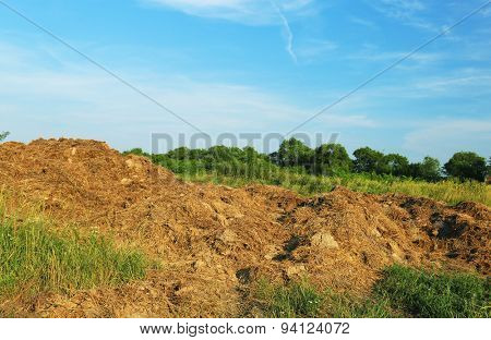 Steaming pile of manure on farm field 