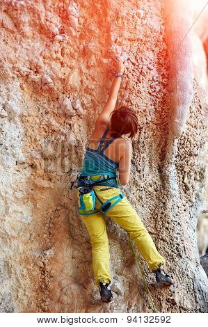 Rock climber climbing up a cliff