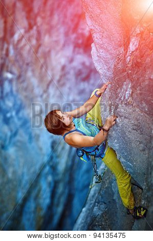 Rock climber climbing up a cliff