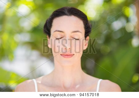 Portrait of a woman in a meditation position against a white backgrou