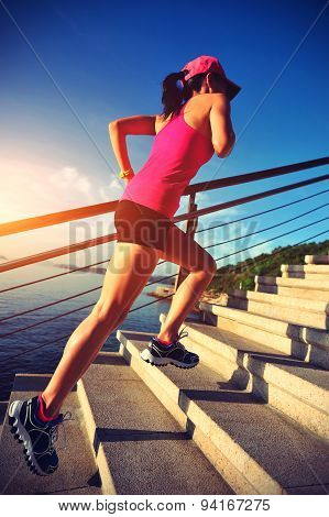 healthy lifestyle sports woman running up on stone stairs seaside