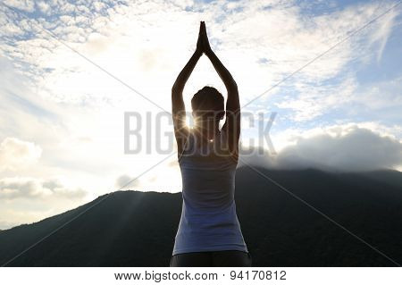 silhouette of young yoga woman at sunrise peak