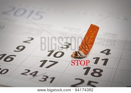 Extinguished Cigarette Butt On The Calendar
