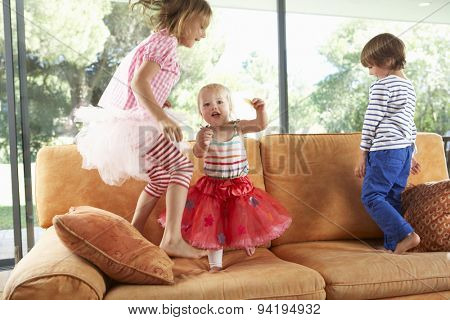 Group Of Children Jumping On Sofa