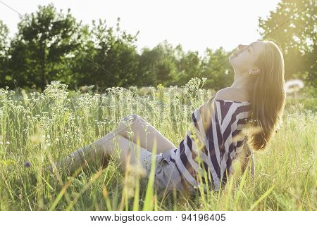 beautiful young woman sitting on hay.