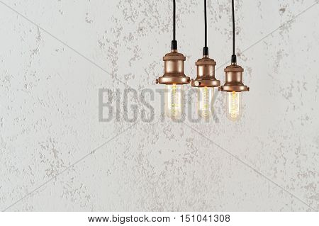Industrial pendant lamps against rough wall. Loft interior. Edison bulbs.