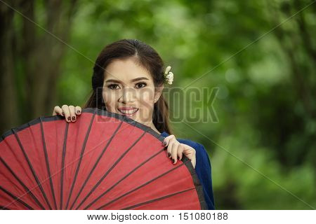 Thai woman portrait with red umbella in countryside of Thailand.