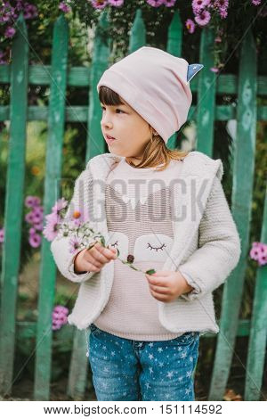girl holding flowers in their hands .