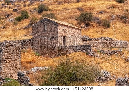 Stone church in the ruins of an ancient ruined fortress Acrocorinth on a hot sunny day.