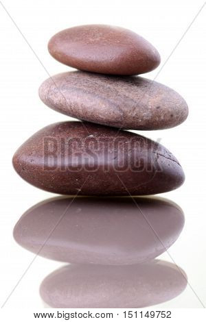 Pile of zenlike stones isolated on white background with reflexion