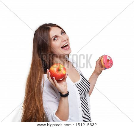 Choose healthy food, diet concept. Beautiful long-haired young woman with big ripe red apple in one hand and a donut in another. Female portrait isolated on white background.