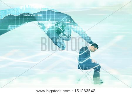 Abstract digital hand contolling young businessman with laptop on abstract background with business charts. Control concept