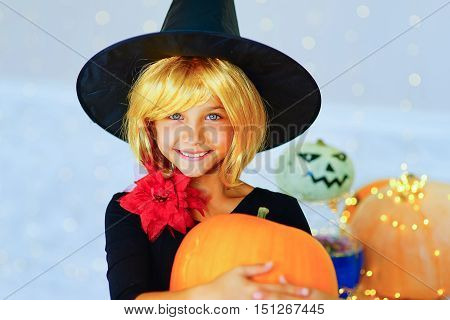 Happy group of witch children pirate and demons during Halloween party playing around the table with pumpkins
