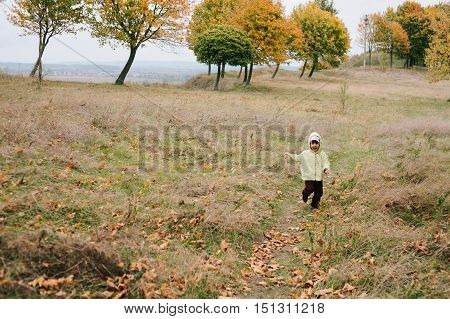 Little girl in the autumn park. run pathway