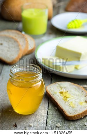 Honey in glass jar on rustic wooden table.