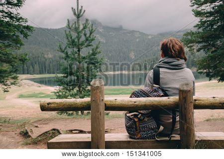 Woman With Backpack Sitting Near Lake And Mountain, Nature Landscape
