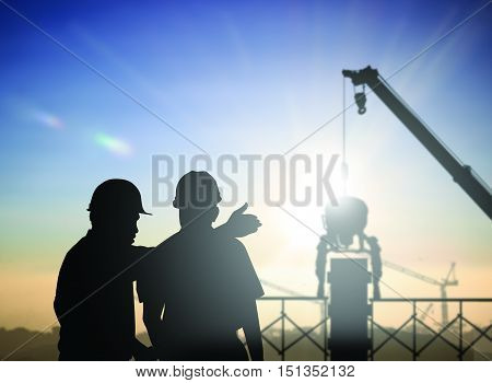 silhouette man survey and civil engineer stand on ground working in a land building site over Blurred construction worker on construction site. examination inspection survey