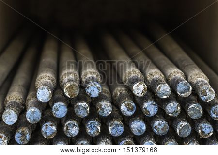 Close up of a box of welding rods taken end on. Blue and white marking on end of rods.