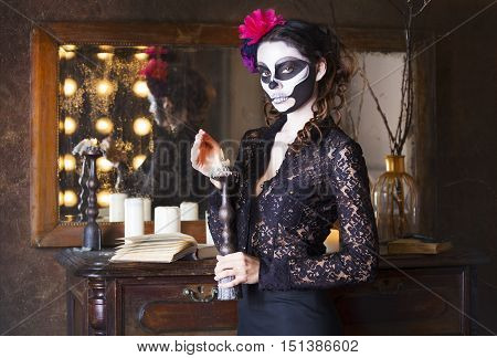 Young beautiful woman painted face as skeleton. Halloween or calavera theme