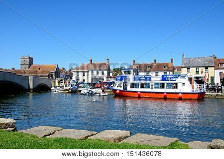 WAREHAM, UNITED KINGDOM - JULY 19, 2016 - Boats moored on the river with views towards the bridge and town Wareham Dorset England UK Western Europe, July 19, 2016.
