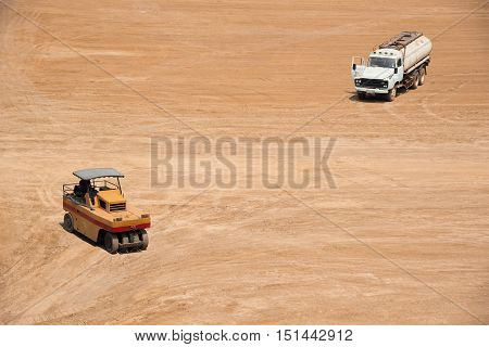 High View Of Space Of Construction Site With Compactor And Water Trunk
