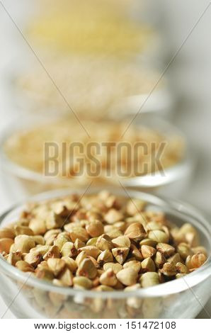 Raw buckwheat groats in a glass bowl with blurred background